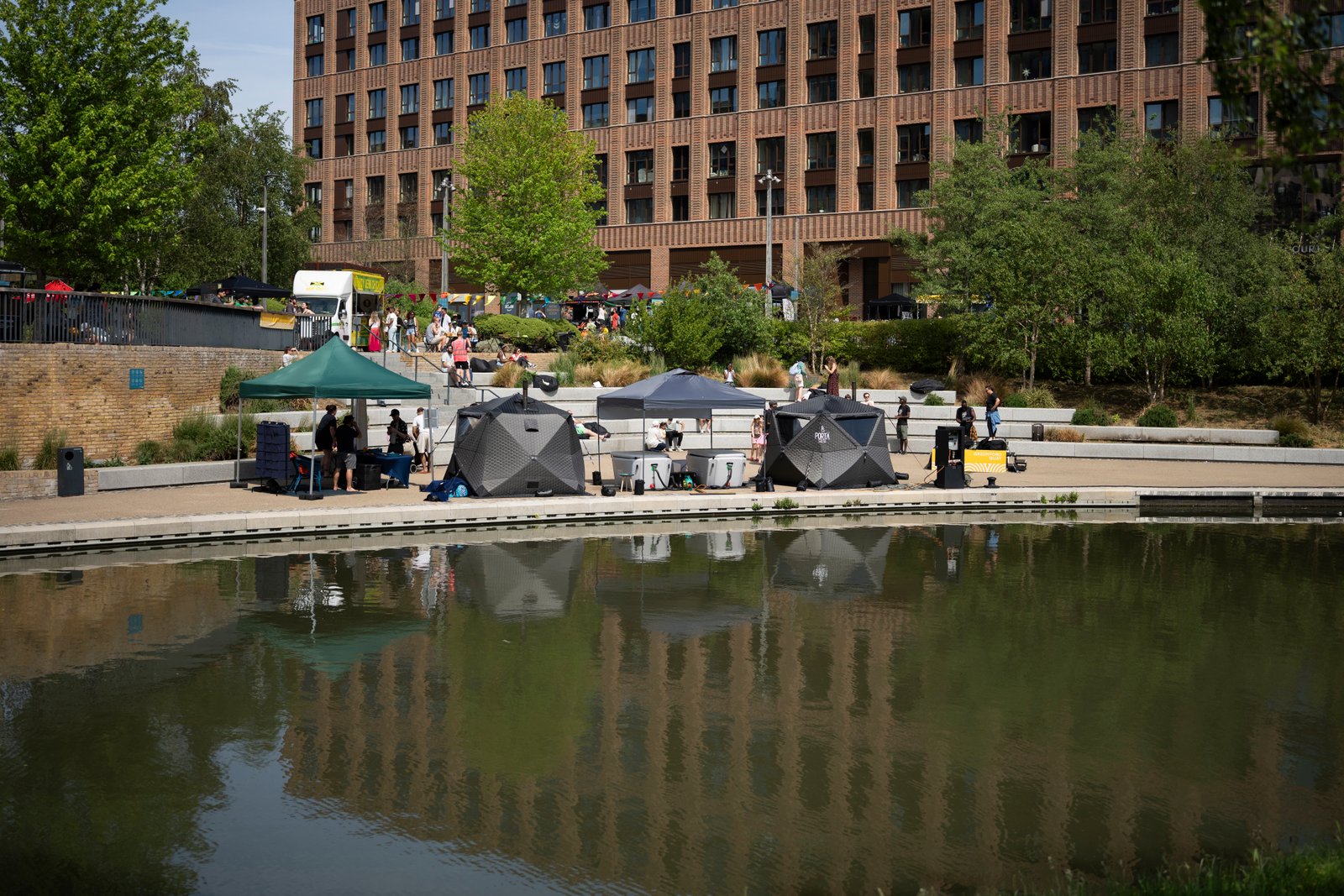 SMÜG sauna and cold plunge set up by a reflective pond at an outdoor event